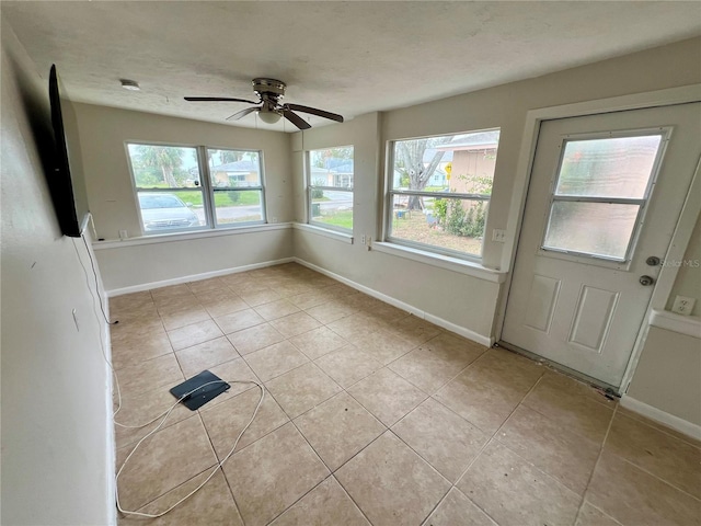 tiled spare room featuring ceiling fan