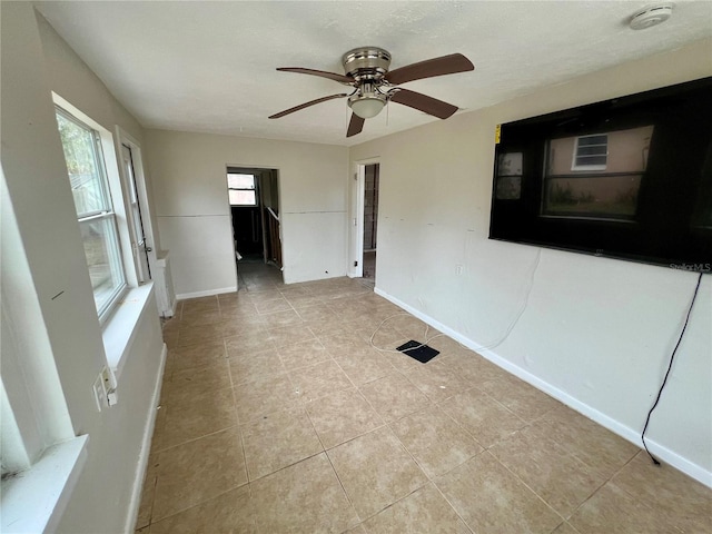 spare room featuring ceiling fan and light tile patterned flooring