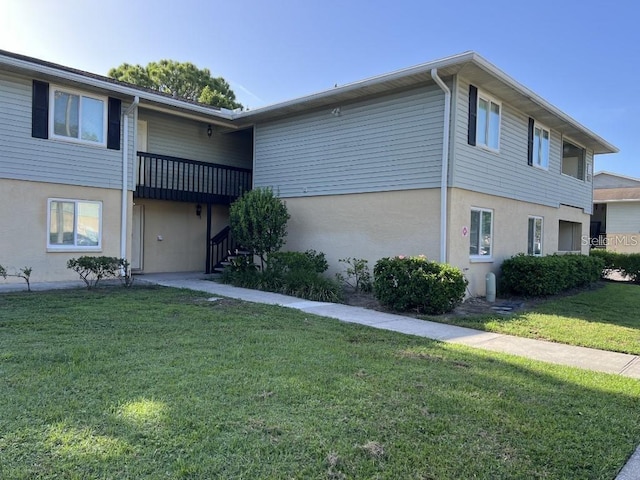 view of front of house with a balcony and a front yard