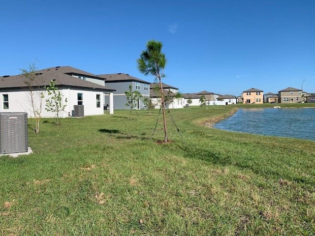 view of yard featuring central air condition unit and a water view