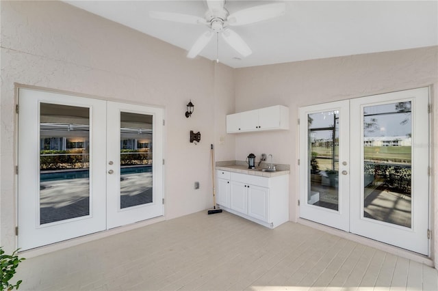 interior space featuring french doors, white cabinetry, and vaulted ceiling