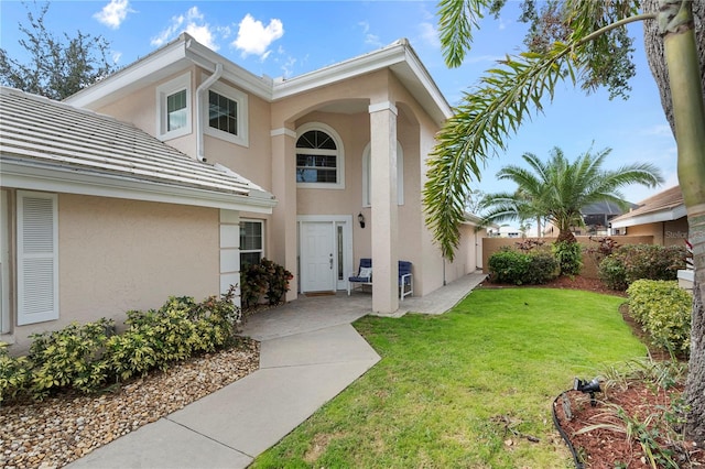 entrance to property with a lawn