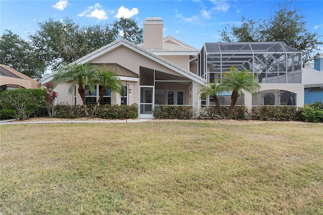 view of front of property with glass enclosure and a front lawn