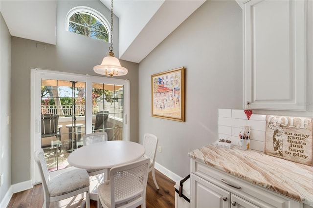 dining area featuring lofted ceiling, plenty of natural light, dark hardwood / wood-style flooring, and a chandelier