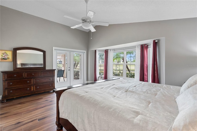 bedroom with dark wood-type flooring, french doors, lofted ceiling, a textured ceiling, and ceiling fan