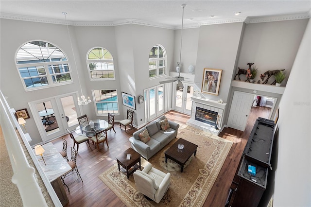 living room with crown molding, wood-type flooring, a tile fireplace, and french doors