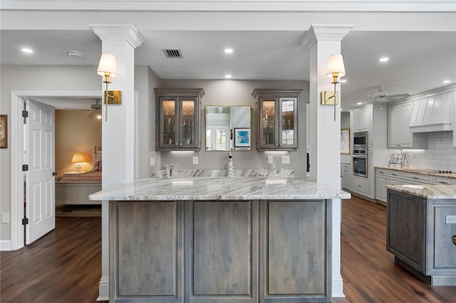 kitchen with ceiling fan, light stone countertops, pendant lighting, and kitchen peninsula