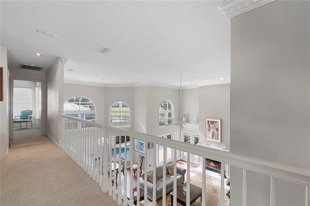 hallway with light colored carpet and ornamental molding