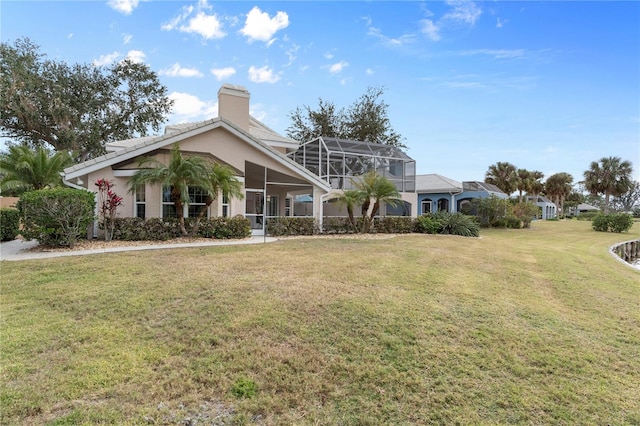 view of front facade with glass enclosure and a front lawn