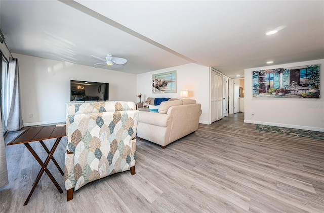 living room with wood-type flooring and ceiling fan