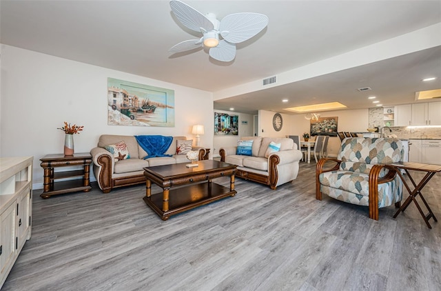 living room with ceiling fan and light wood-type flooring