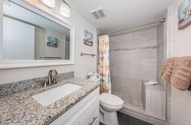 bathroom with vanity, a shower with shower curtain, and toilet