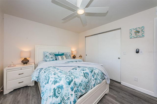 bedroom with ceiling fan, dark wood-type flooring, and a closet