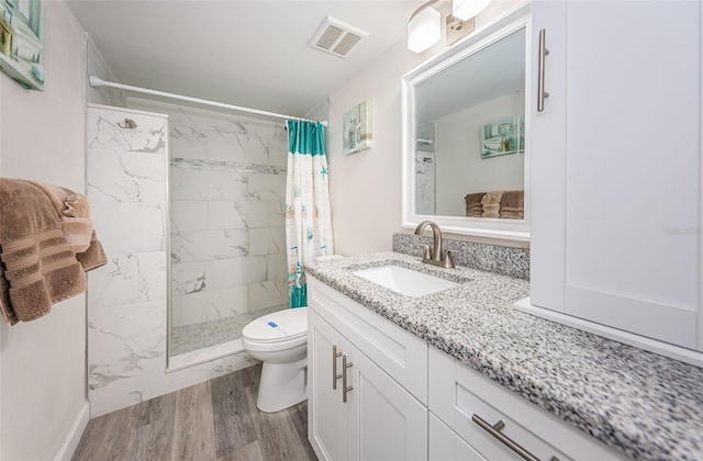 bathroom featuring toilet, vanity, a shower with shower curtain, and hardwood / wood-style flooring