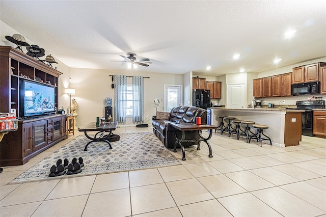 tiled living room featuring ceiling fan and a textured ceiling