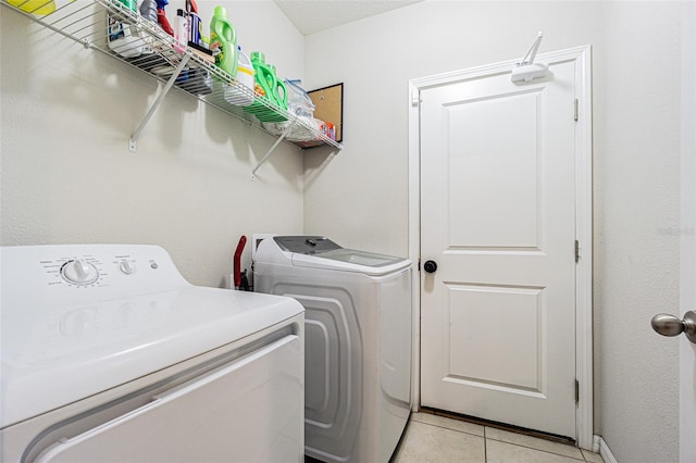 washroom with washer and dryer and light tile patterned floors