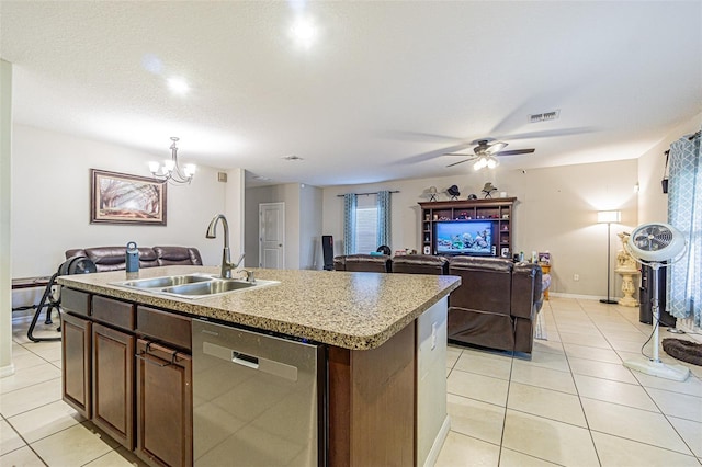 kitchen with sink, an island with sink, stainless steel dishwasher, and light tile patterned floors