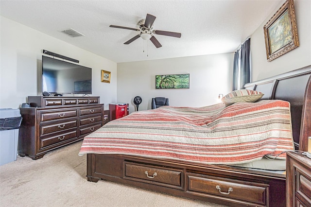 carpeted bedroom with a textured ceiling and ceiling fan