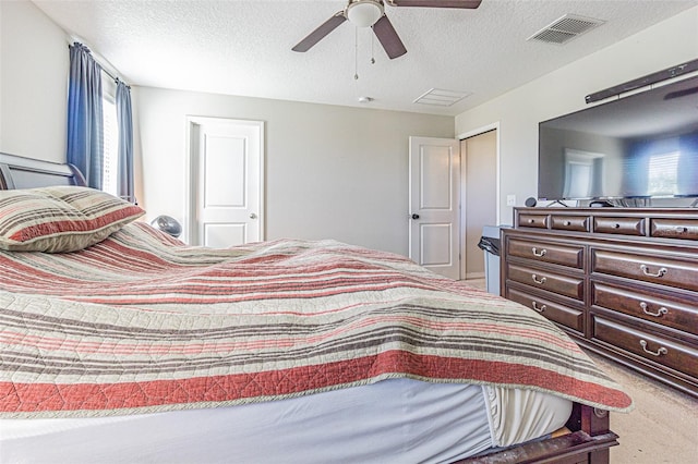 bedroom with carpet flooring, ceiling fan, and a textured ceiling