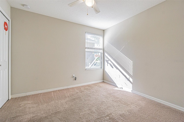 unfurnished room with a textured ceiling, ceiling fan, and light carpet