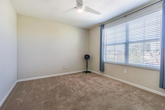 unfurnished room with carpet, ceiling fan, and a textured ceiling