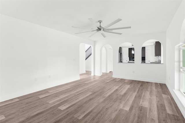 unfurnished living room with ceiling fan and light wood-type flooring