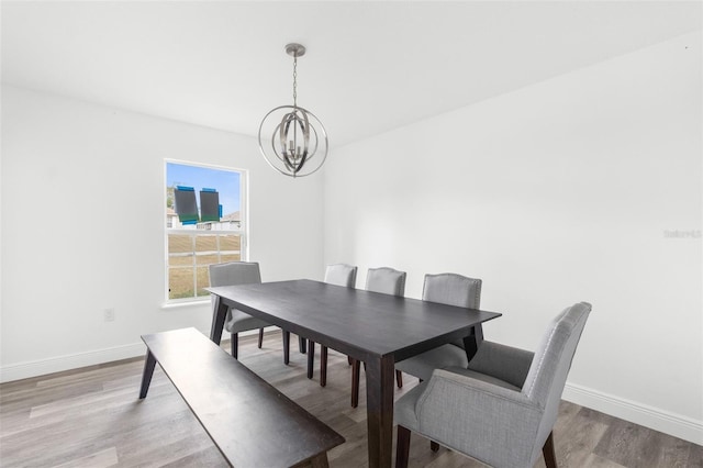 dining room featuring light wood-type flooring and an inviting chandelier