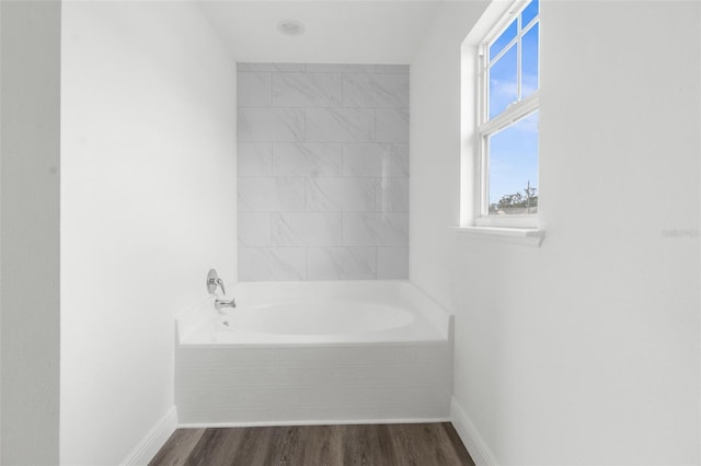 bathroom featuring a washtub and wood-type flooring