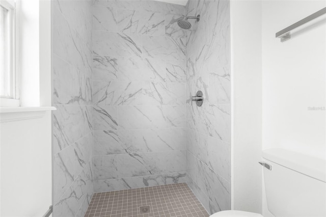 bathroom featuring toilet and a tile shower