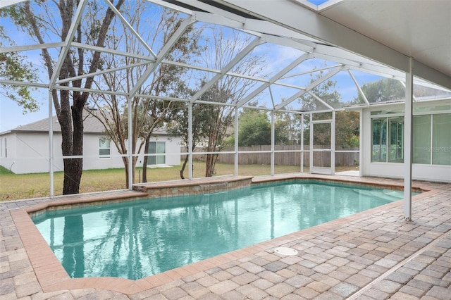 view of swimming pool with glass enclosure and a patio area