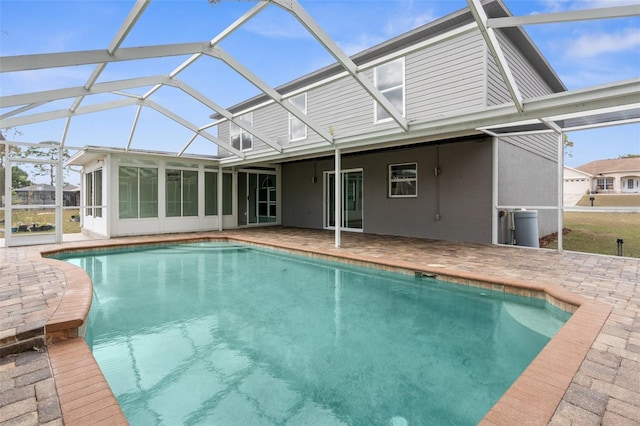 view of pool featuring a patio, glass enclosure, and a sunroom