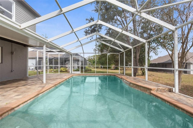 view of swimming pool with glass enclosure and a patio