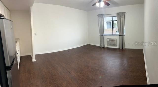 unfurnished room featuring ceiling fan, an AC wall unit, and dark hardwood / wood-style flooring