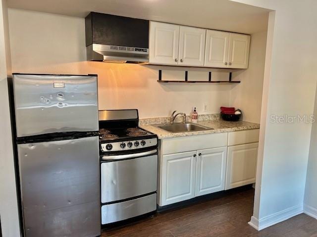 kitchen with white cabinetry, appliances with stainless steel finishes, dark hardwood / wood-style flooring, and range hood