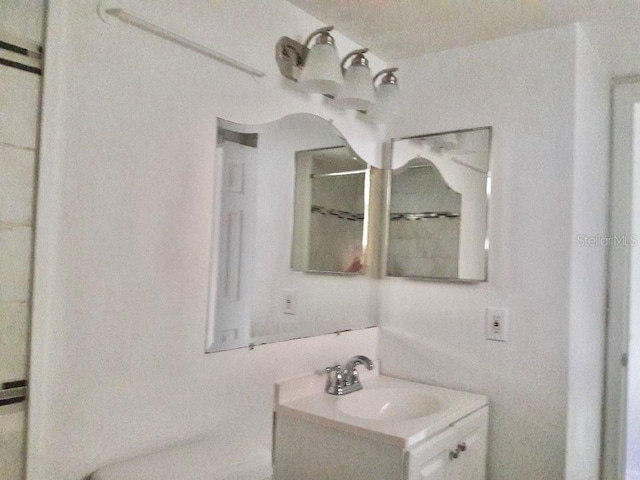 bathroom featuring walk in shower and vanity