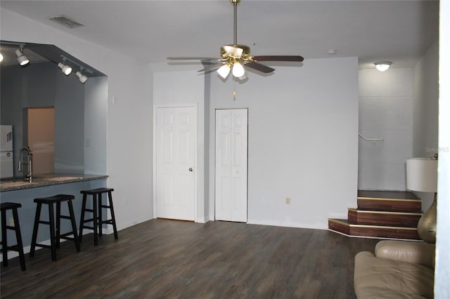 living room featuring dark hardwood / wood-style floors, ceiling fan, and sink