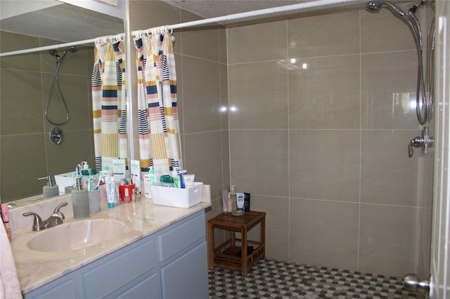 bathroom featuring a shower with shower curtain, vanity, and a textured ceiling