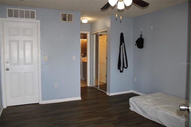 bedroom with ceiling fan, dark hardwood / wood-style floors, and a closet