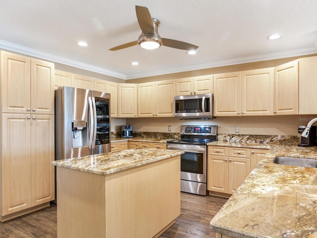 kitchen with light stone counters, ornamental molding, stainless steel appliances, sink, and a center island