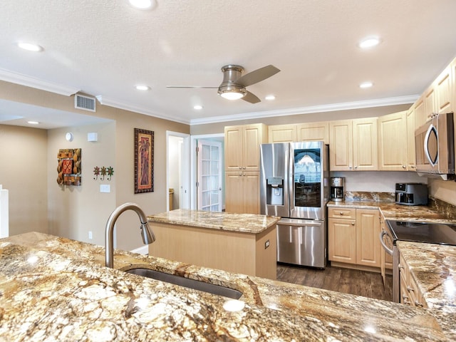 kitchen with a center island, sink, ceiling fan, light stone counters, and stainless steel appliances