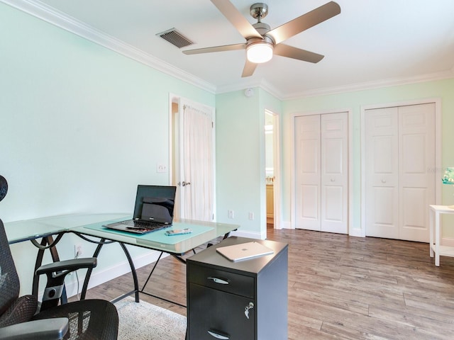 home office with crown molding, ceiling fan, and light wood-type flooring