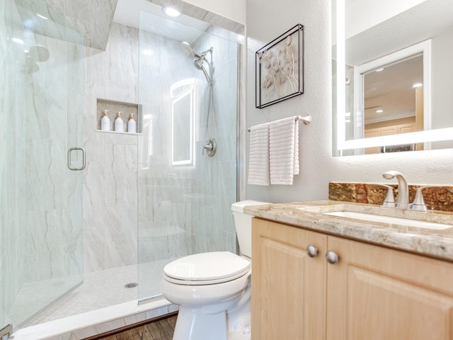 bathroom featuring vanity, toilet, a shower with shower door, and wood-type flooring