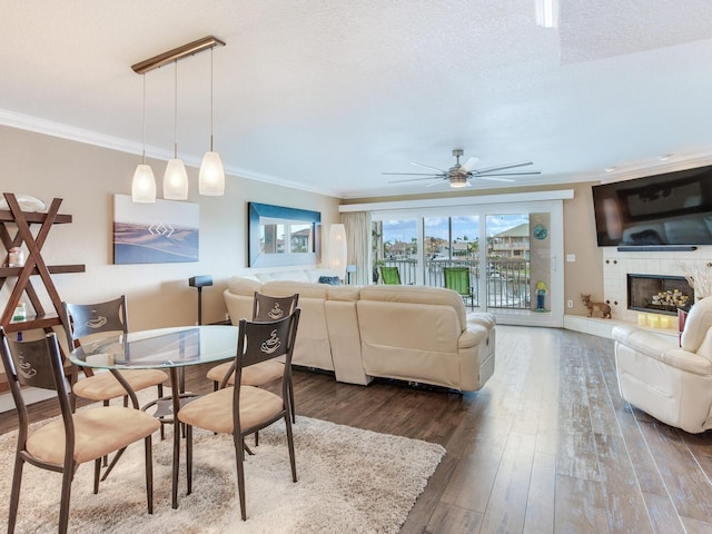 dining area featuring a textured ceiling, dark hardwood / wood-style floors, ceiling fan, and crown molding