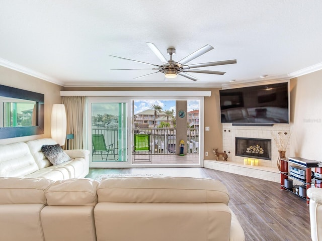 living room with wood-type flooring, ceiling fan, and crown molding