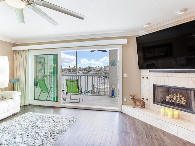 unfurnished living room featuring hardwood / wood-style flooring, ornamental molding, and a fireplace