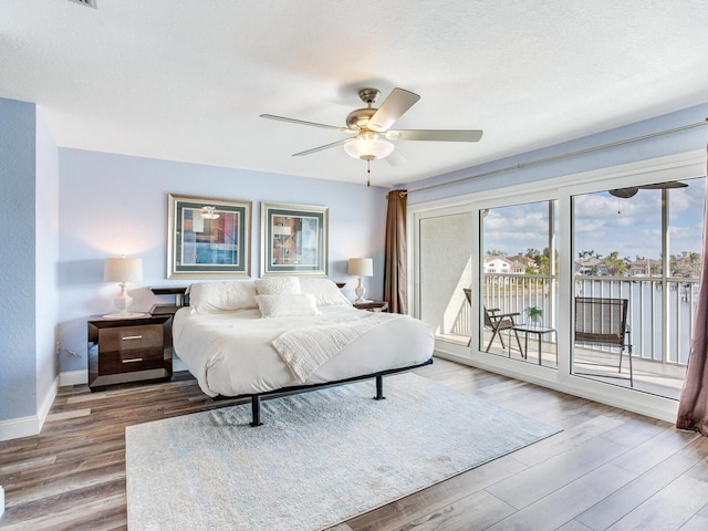 bedroom with hardwood / wood-style flooring, ceiling fan, access to exterior, and a textured ceiling