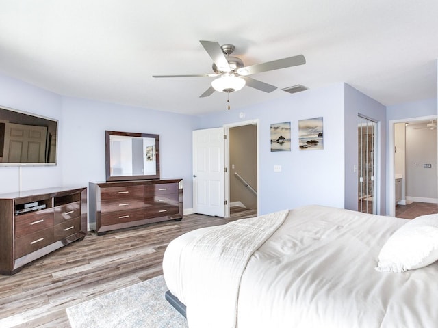 bedroom with a closet, light hardwood / wood-style floors, ceiling fan, and ensuite bathroom