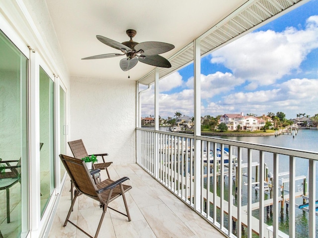 balcony with ceiling fan and a water view