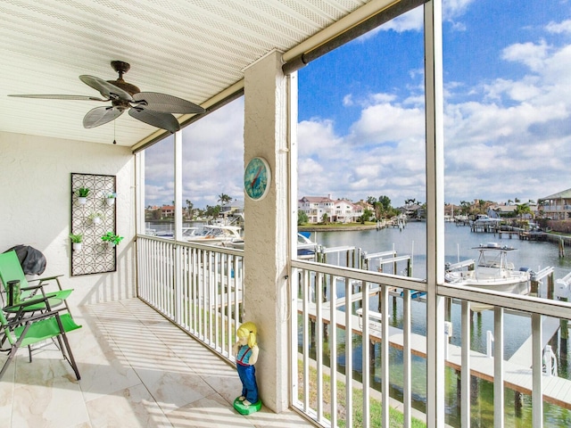 unfurnished sunroom featuring ceiling fan, a healthy amount of sunlight, and a water view