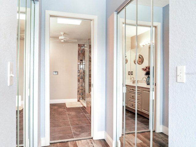 bathroom featuring ceiling fan, walk in shower, and vanity